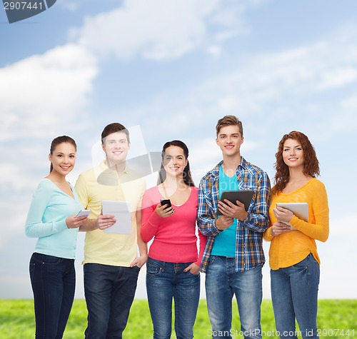 Image of group of teenagers with smartphones and tablet pc