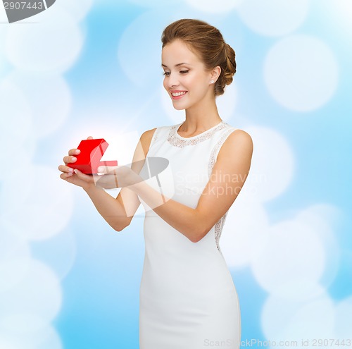 Image of smiling woman holding red gift box