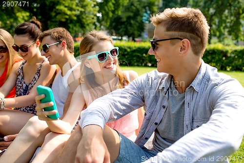 Image of smiling friends with smartphone making selfie