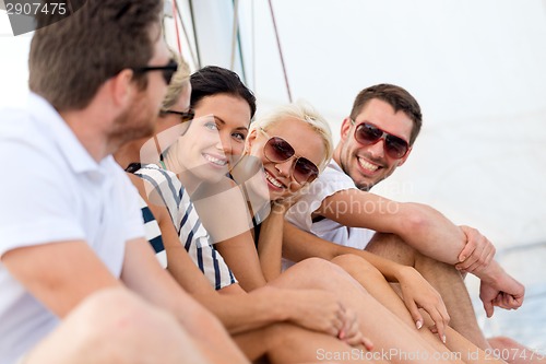 Image of smiling friends sitting on yacht deck