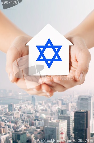 Image of close up of hands holding house with star of david