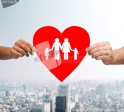 Image of couple hands holding red heart with family