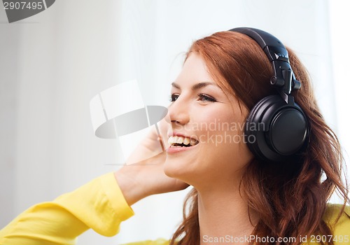 Image of smiling young girl in headphones at home