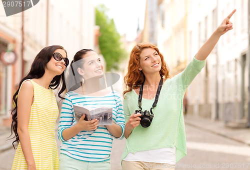 Image of smiling teenage girls with city guide and camera