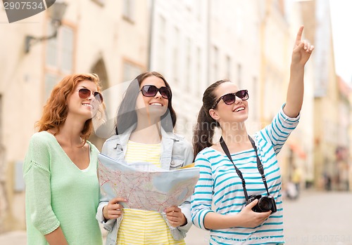 Image of smiling teenage girls with map and camera