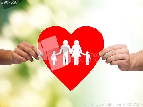 Image of closeup of hands holding red heart with family