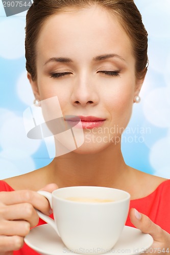 Image of smiling woman in red dress with cup of coffee