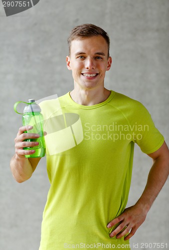 Image of smiling man with bottle of water in gym