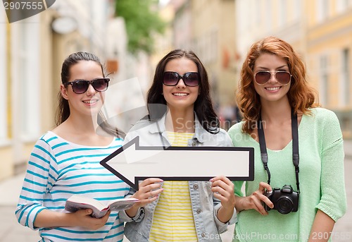 Image of smiling teenage girls with white arrow outdoors