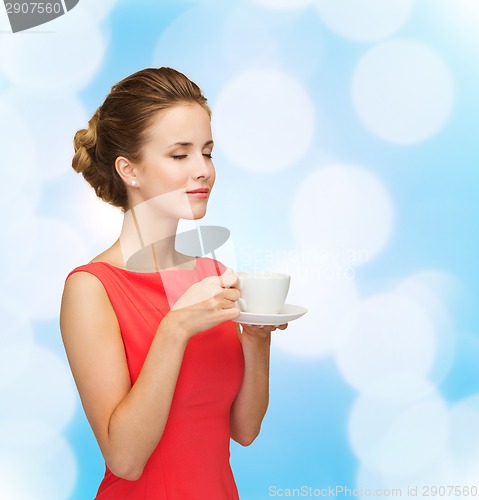 Image of smiling woman in red dress with cup of coffee