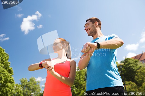 Image of smiling people with heart rate watches outdoors