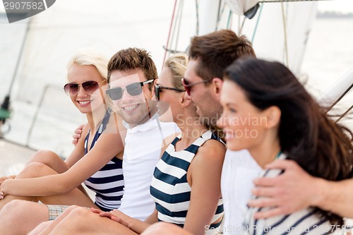 Image of smiling friends sitting on yacht deck