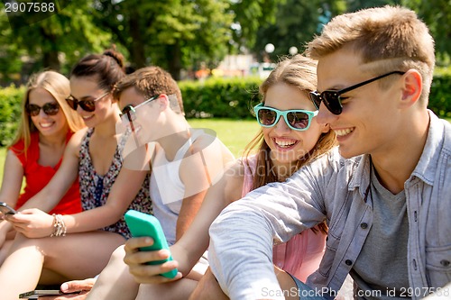 Image of smiling friends with smartphone making selfie