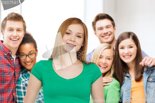 Image of group of smiling teenagers over classroom