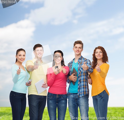 Image of group of teenagers with smartphones and tablet pc