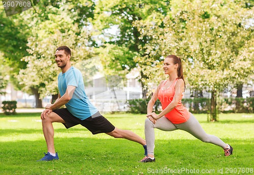 Image of smiling couple stretching outdoors