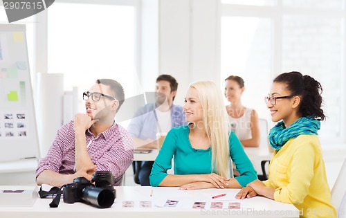 Image of smiling team with photocamera working in office