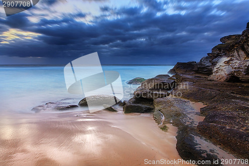 Image of Stunning beach and coastal rocks before sunrise