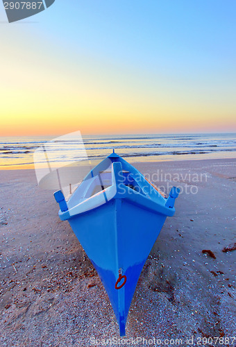 Image of fishing boat on the seashore at sunrise