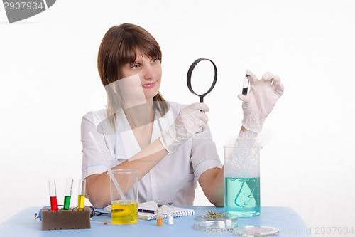 Image of Scientist examines medicine through a magnifying glass