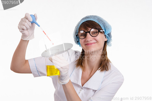 Image of Chemist liquid drips into a flask