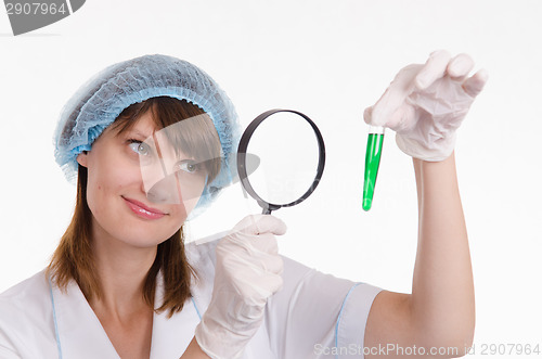 Image of Chemist examines liquid in a test tube