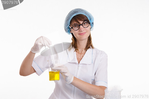 Image of Chemist mixes the contents of flask