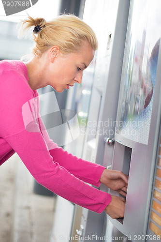 Image of Lady collecting product from vending machine.