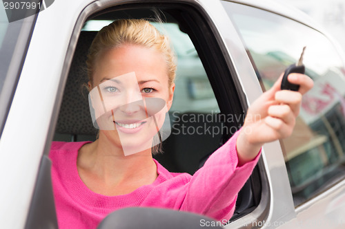 Image of Caucasian lady showing a car key.