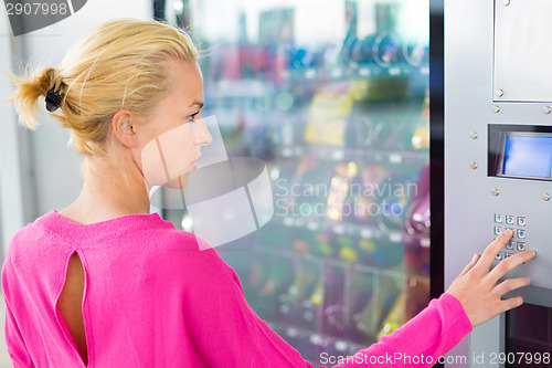 Image of Lady using  a modern vending machine