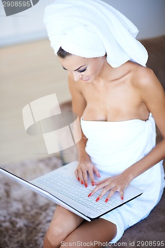 Image of Woman Wearing Bath Towel Using Laptop Computer
