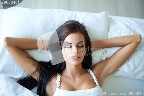 Image of Attractive young woman having a lie in