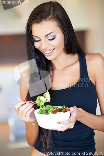 Image of Young woman eating a healthy fresh salad