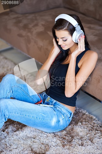 Image of Woman relaxing on the floor listening to music