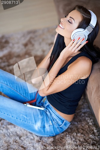 Image of Woman relaxing on the floor listening to music