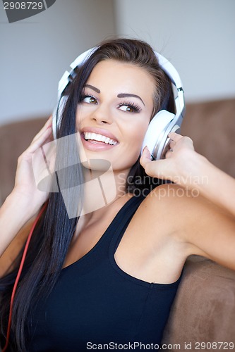 Image of Happy tanned young woman enjoying her music