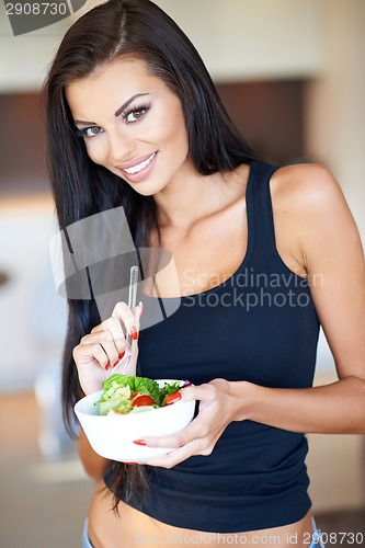 Image of Healthy woman eating a fresh mixed salad