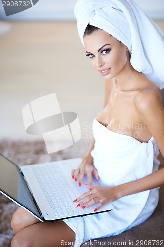 Image of Woman Wearing Bath Towel Using Laptop Computer