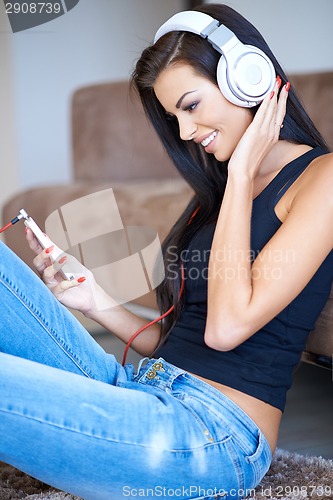 Image of Happy young woman relaxing listening to music