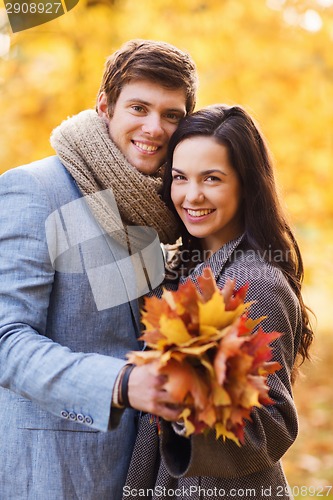 Image of smiling couple hugging in autumn park