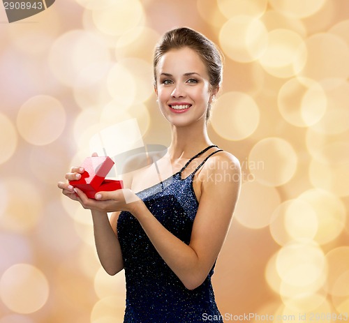 Image of smiling woman holding red gift box