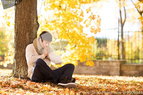 Image of smiling young man with tablet pc in autumn park