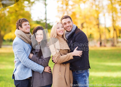 Image of group of smiling men and women in autumn park