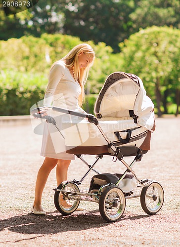 Image of happy mother with stroller in park