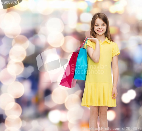 Image of smiling little girl in dress with shopping bags