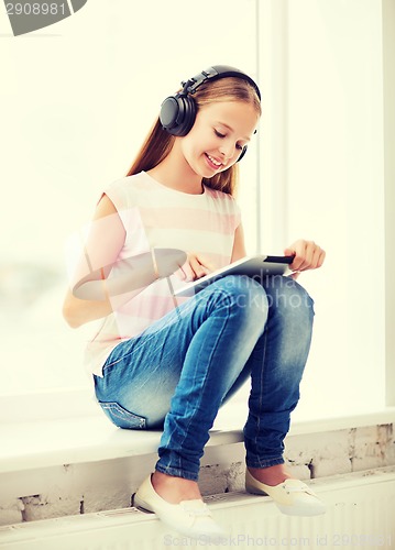 Image of girl with tablet pc and headphones at home