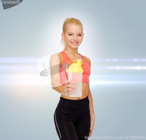 Image of smiling sporty woman with protein shake bottle