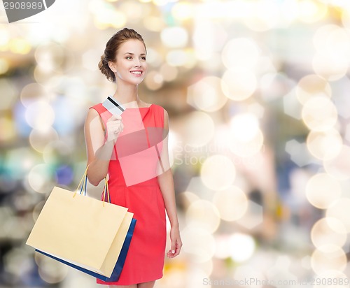 Image of smiling woman with shopping bags and plastic card