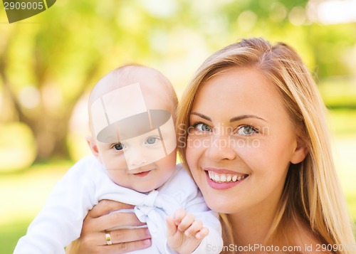 Image of close up of happy mother with little baby in park