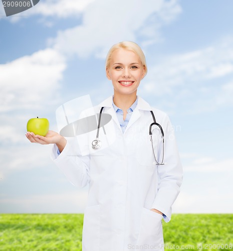 Image of smiling female doctor with green apple